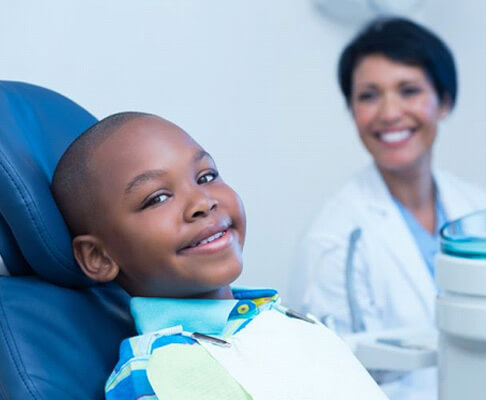smiling young boy in dental treatment chair